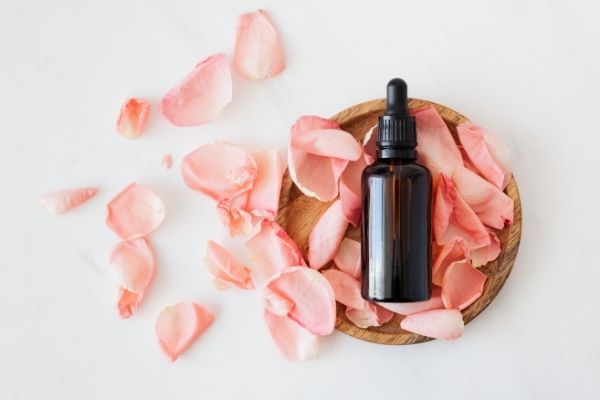 Earth Day- A bottle of essential oil surrounded by rose petals