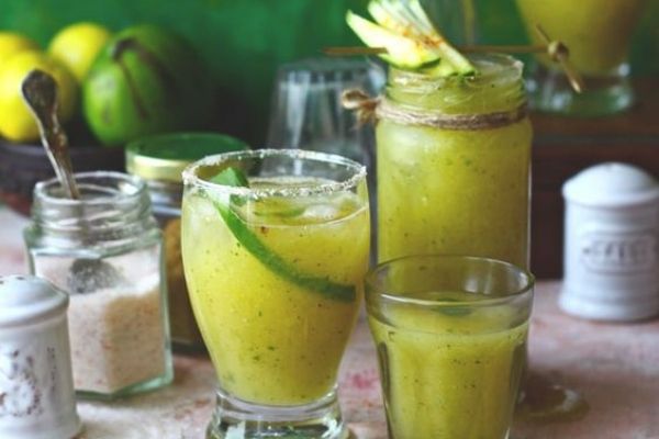 Mango Drink Recipes: Glasses of aam panna with raw mangoes and black salt in the background