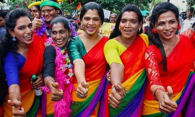 Members of the transgender community stand together in Pride colour themed sarees