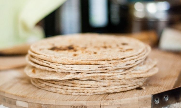A stack of rotis kept on a wooden base